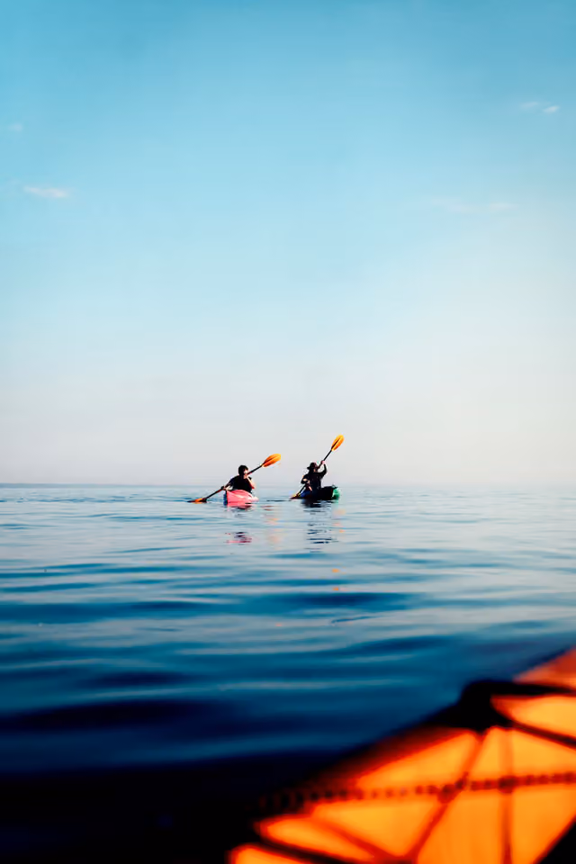 A kayaker on a calm, bright blue sea